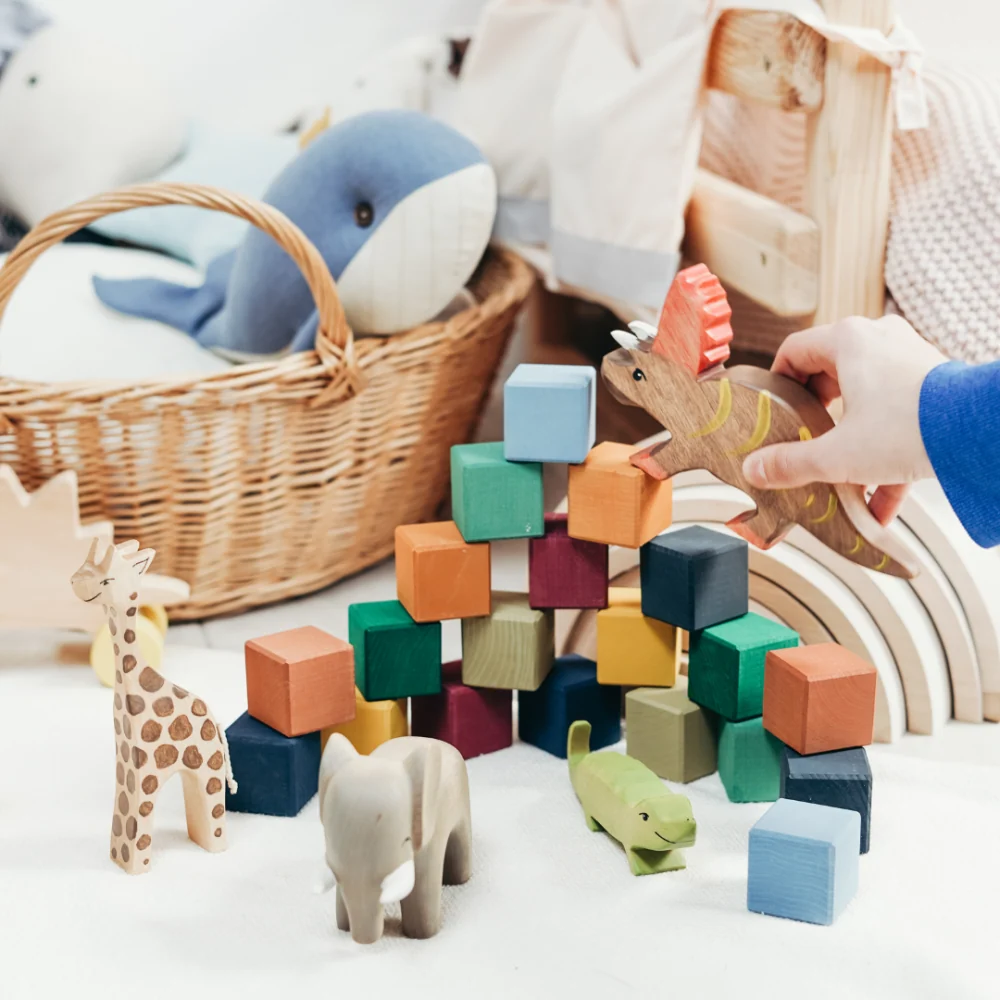 Wooden animals, building blocks and a child's hand at play